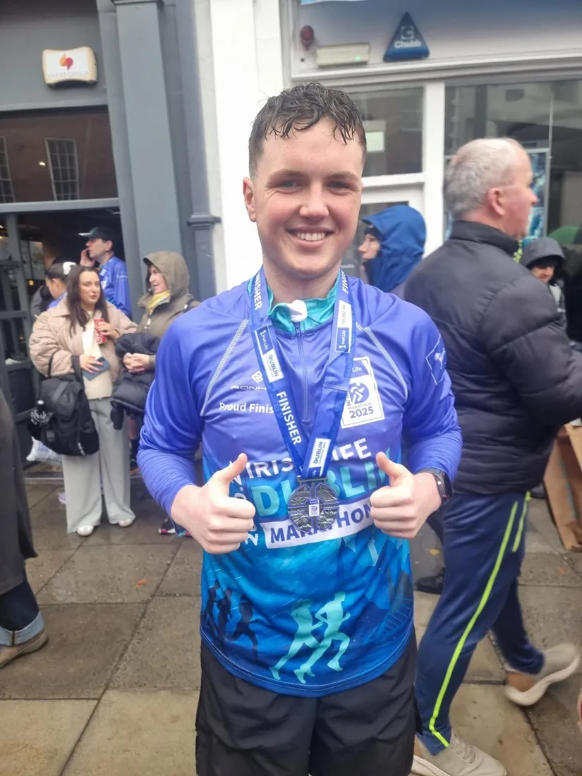 Dylan at the Dublin Marathon finish, medal on, two thumbs up